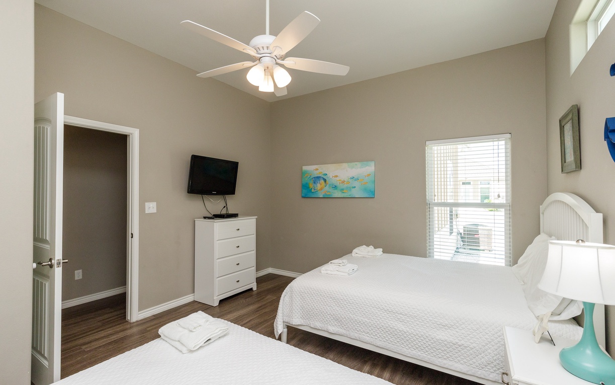Relax in your spacious bedroom with two comfortable queen beds, ceiling fan, and TV for peaceful evenings after exploring.