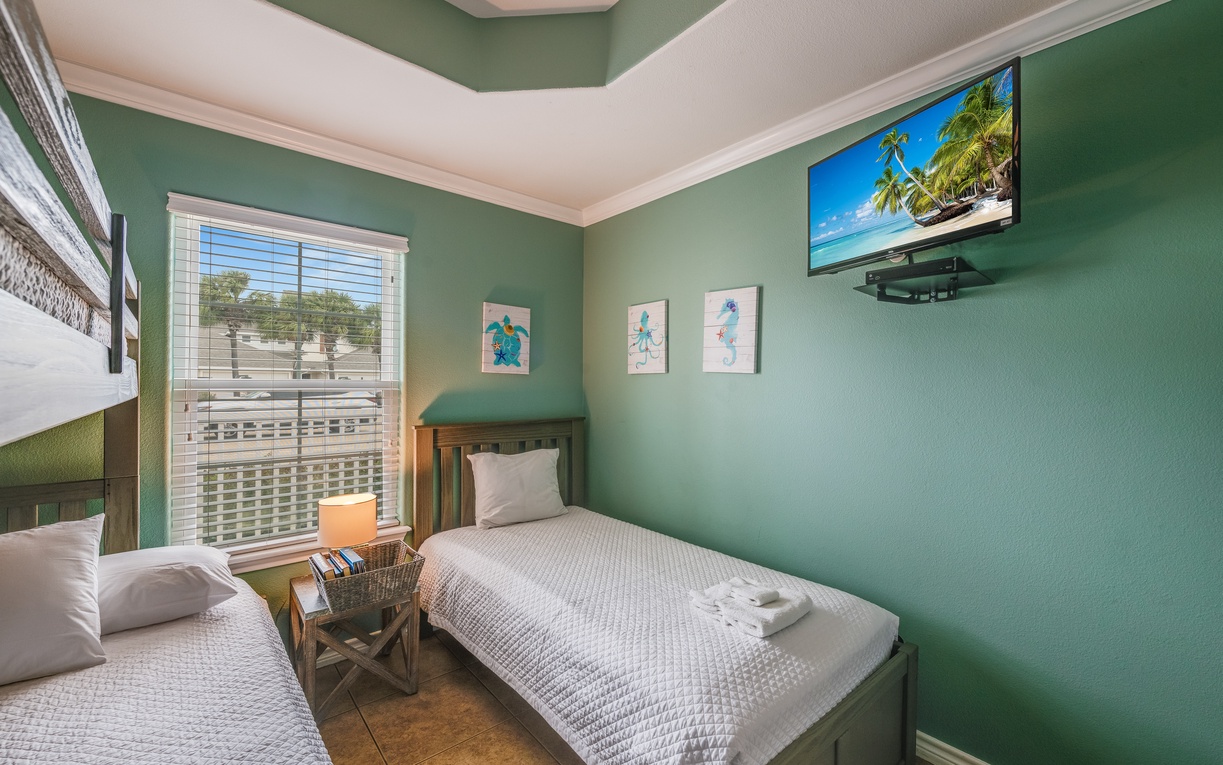 Your peaceful retreat with serene green walls, comfortable twin beds, and tropical artwork to inspire sweet dreams.