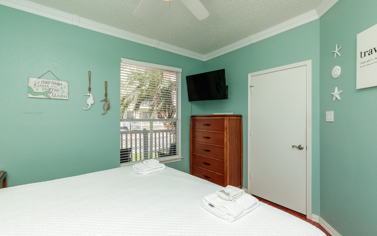 Drift off in your coastal-themed bedroom with cheerful aqua walls, crisp linens, and tropical touches that create your perfect beach getaway retreat.