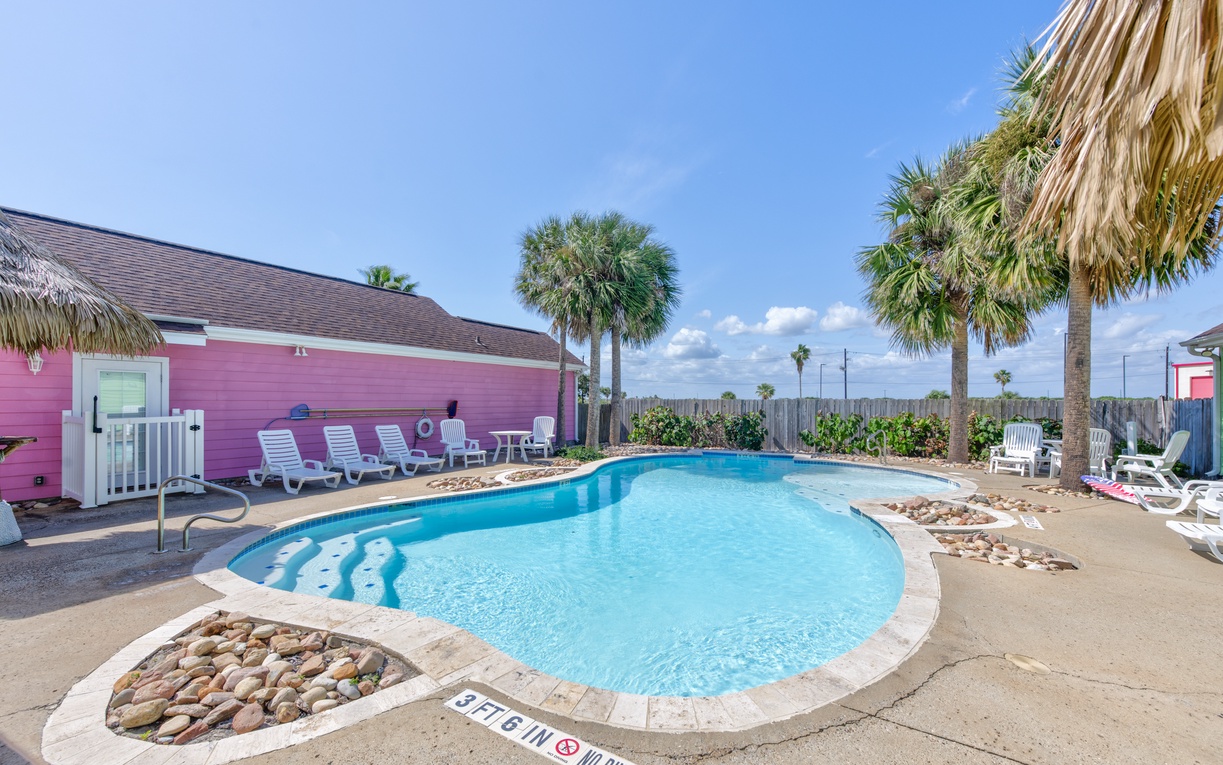 Dive into your private tropical oasis with sparkling pool waters surrounded by swaying palms and colorful beachside charm.