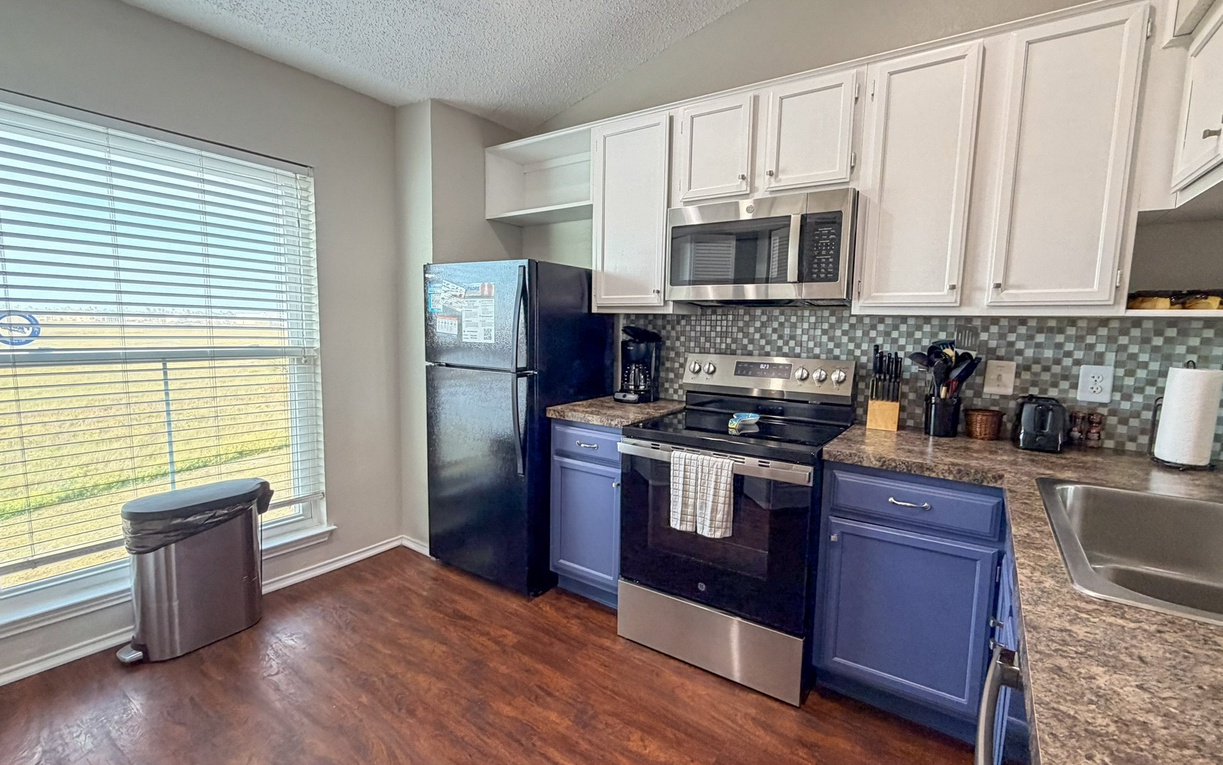 Cook your favorite meals in this fully-equipped kitchen featuring granite countertops, stainless steel appliances, and all the tools you need for a perfect stay.
