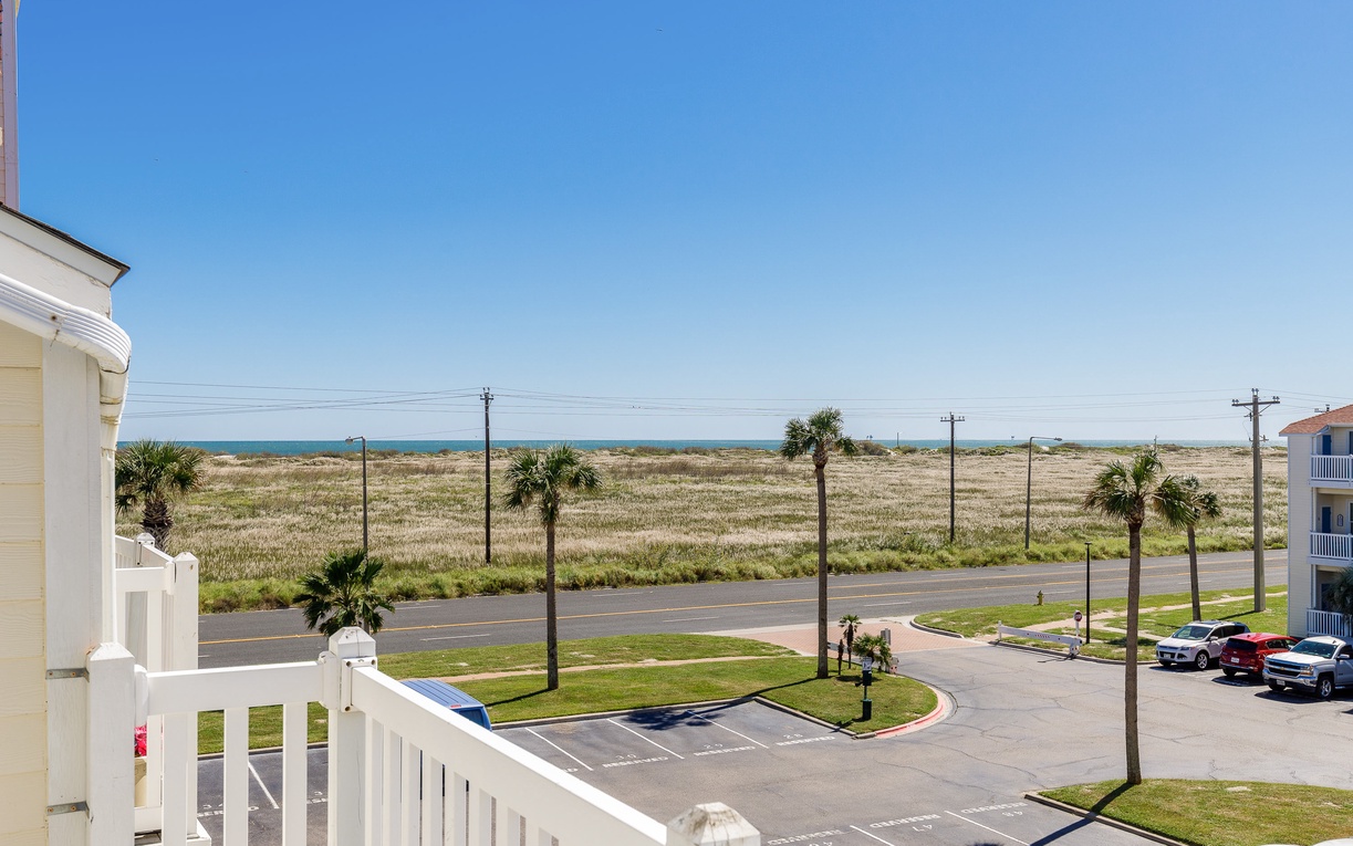 Coastal property view showcasing nearby beach access and surrounding area with palm trees and open landscape.
