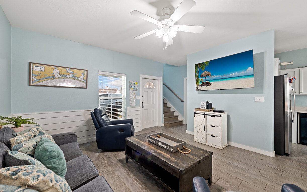 Settle into your living room's coastal calm, where soft blue walls and natural light create the perfect backdrop for unwinding after beach days.