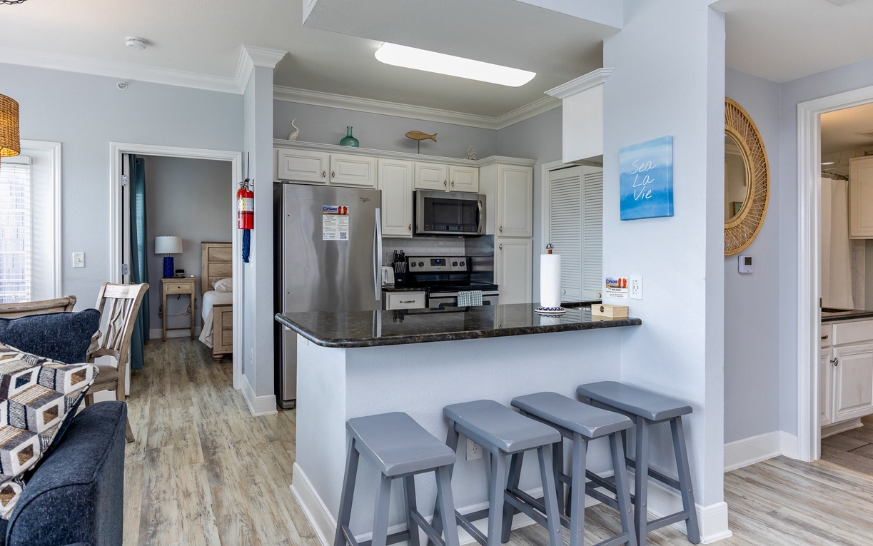 Gather around your stylish kitchen island with modern stools, perfect for morning coffee or casual dining in this bright, open-concept space.