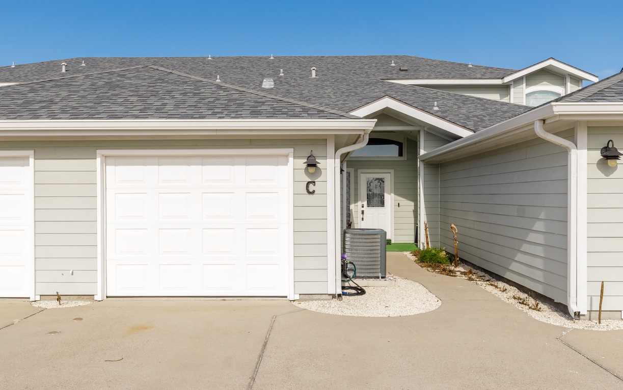 Modern vacation home exterior featuring a welcoming entrance under clear blue skies.