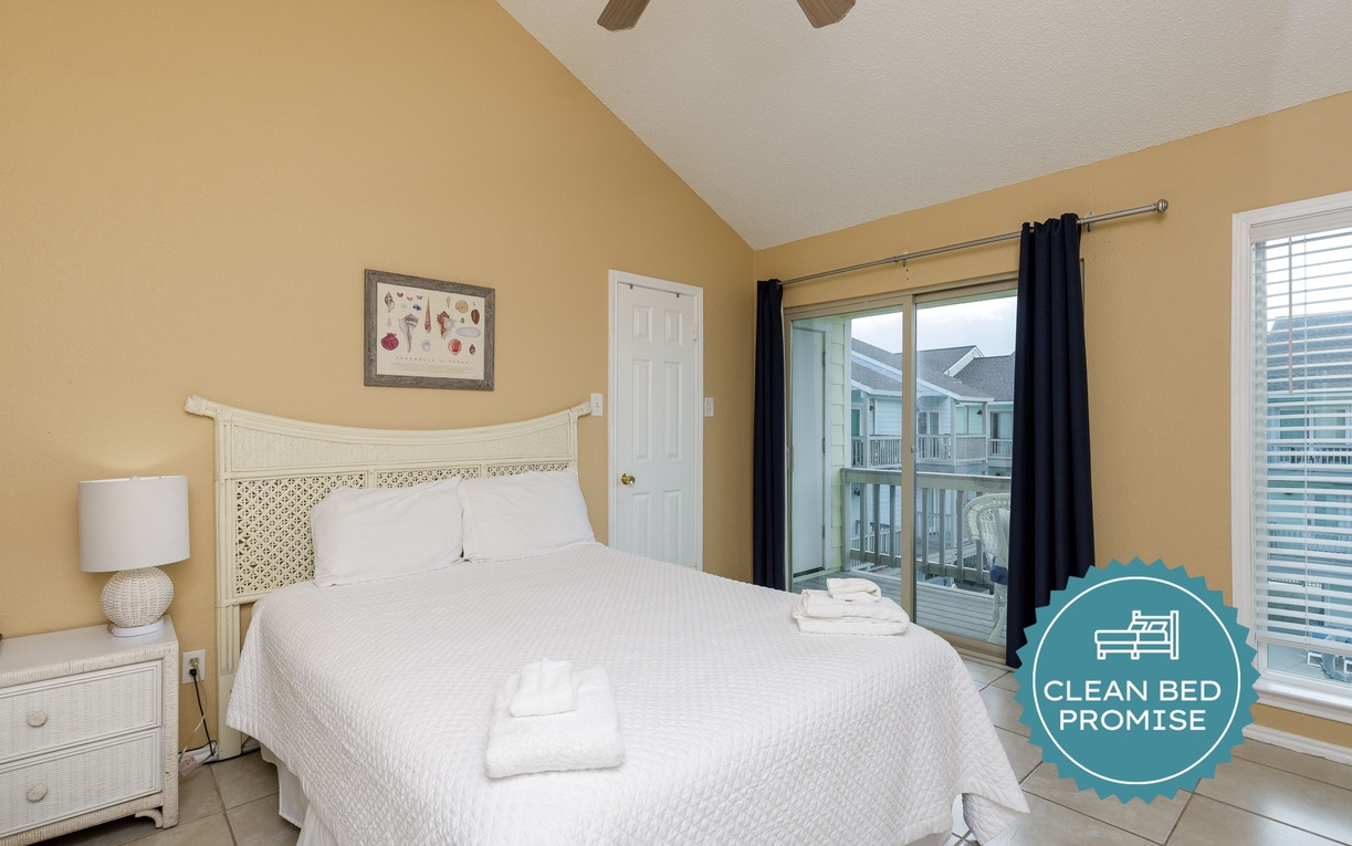 Your bright bedroom features crisp linens, warm coastal colors, and sliding doors opening to your private outdoor space for morning breezes.