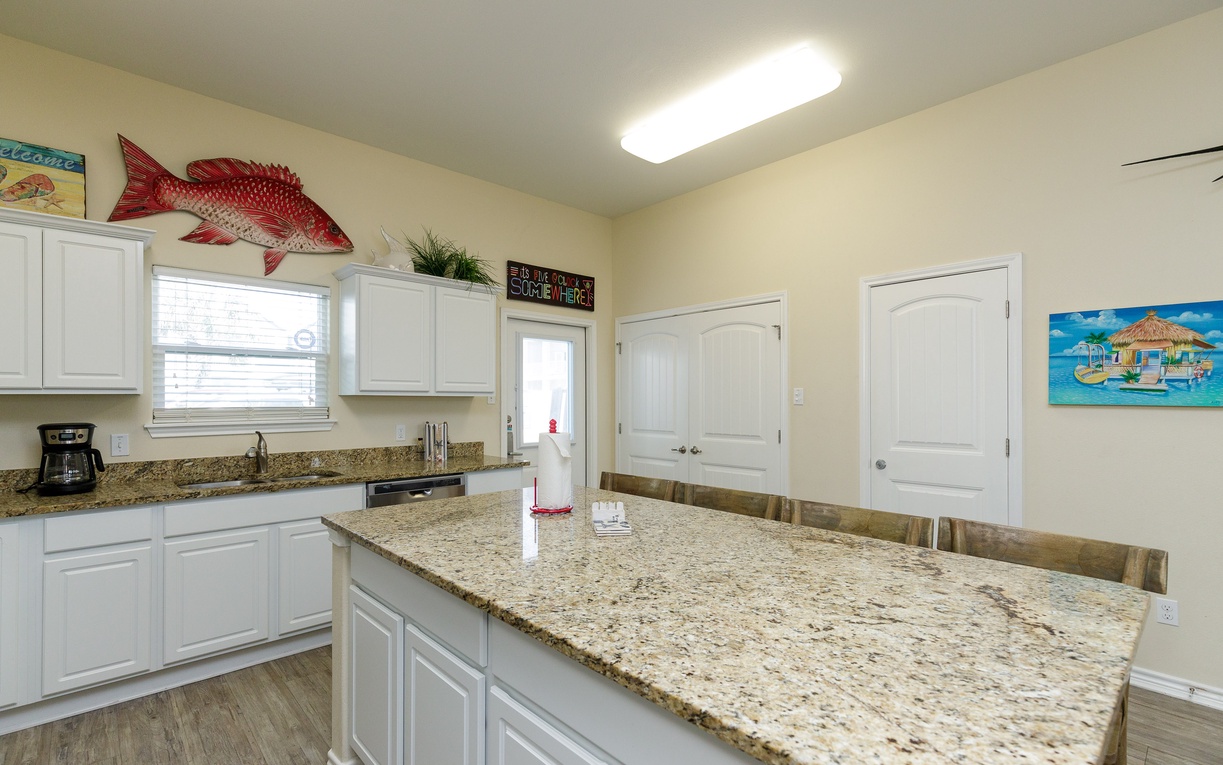 Your spacious kitchen features granite countertops, modern appliances, and charming coastal decor, creating the perfect space for preparing memorable vacation meals.
