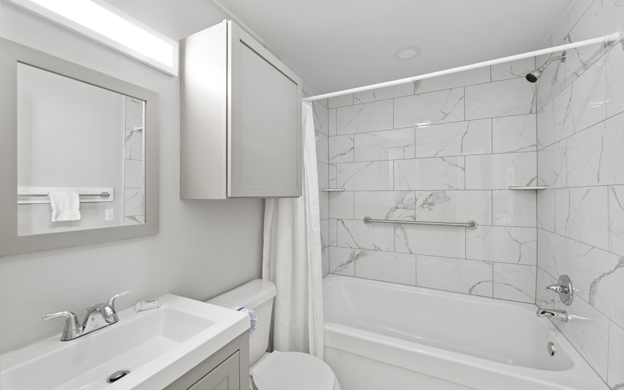Your primary bathroom features elegant marble-look tiles and a relaxing tub-shower combo, perfect for unwinding after a day of fun in the sun.