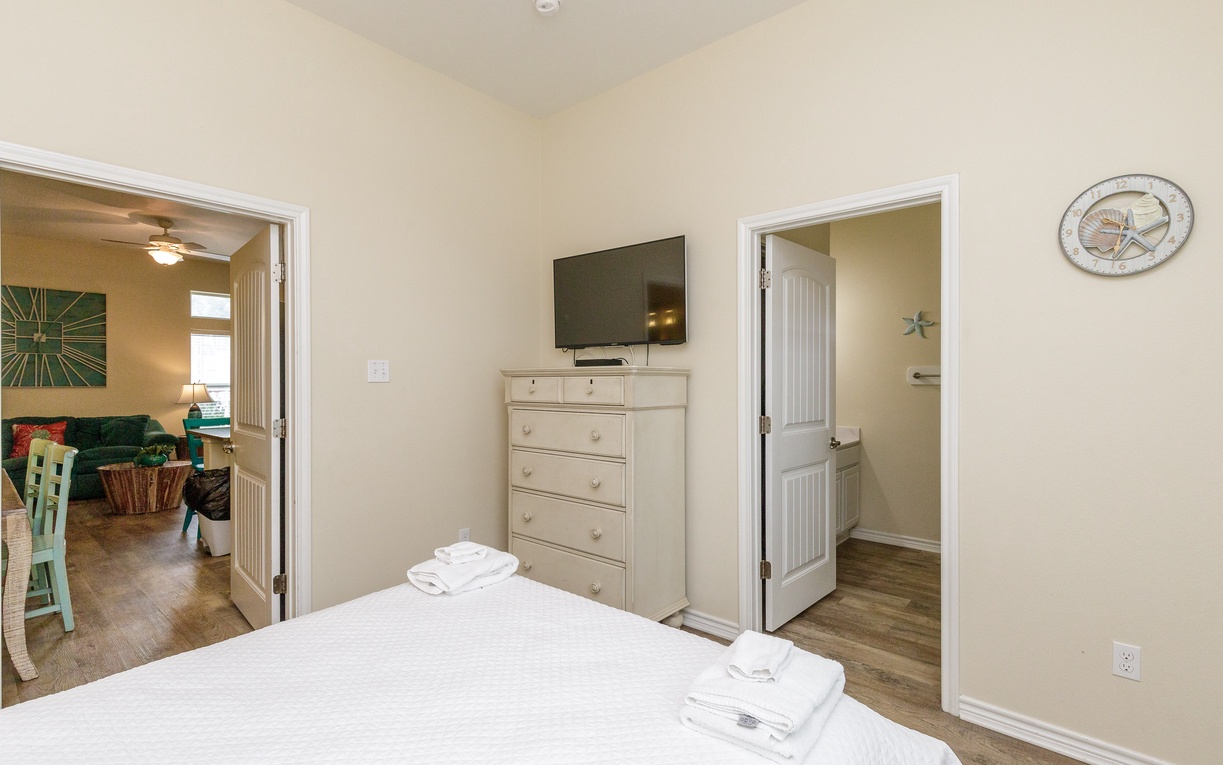 Your peaceful bedroom features crisp linens, coastal decor, and fresh towels ready for your stay.