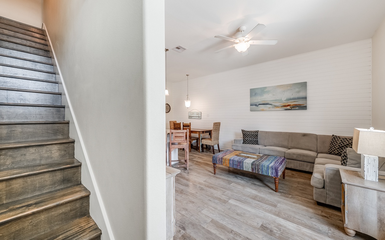 Sink into your cozy living space with comfortable seating, warm lighting, and coastal artwork creating the perfect retreat.