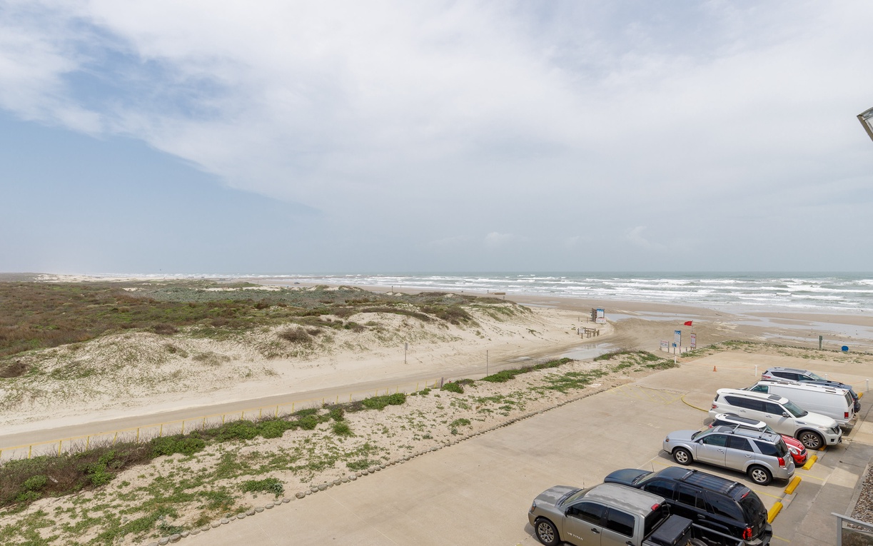 Expansive beachfront stretches endlessly along the coastline, with convenient parking and direct beach access for guests.