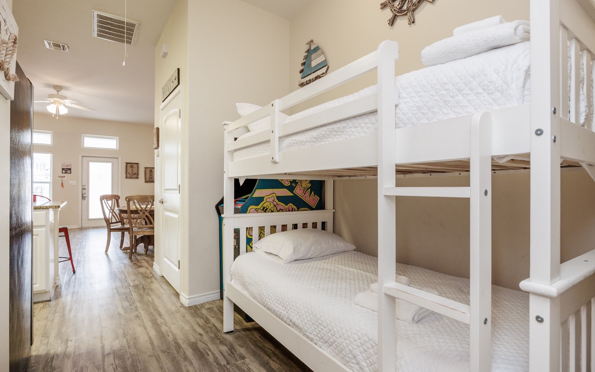 Rest comfortably in these charming white bunk beds with crisp linens and playful nautical touches, perfect for your coastal getaway.