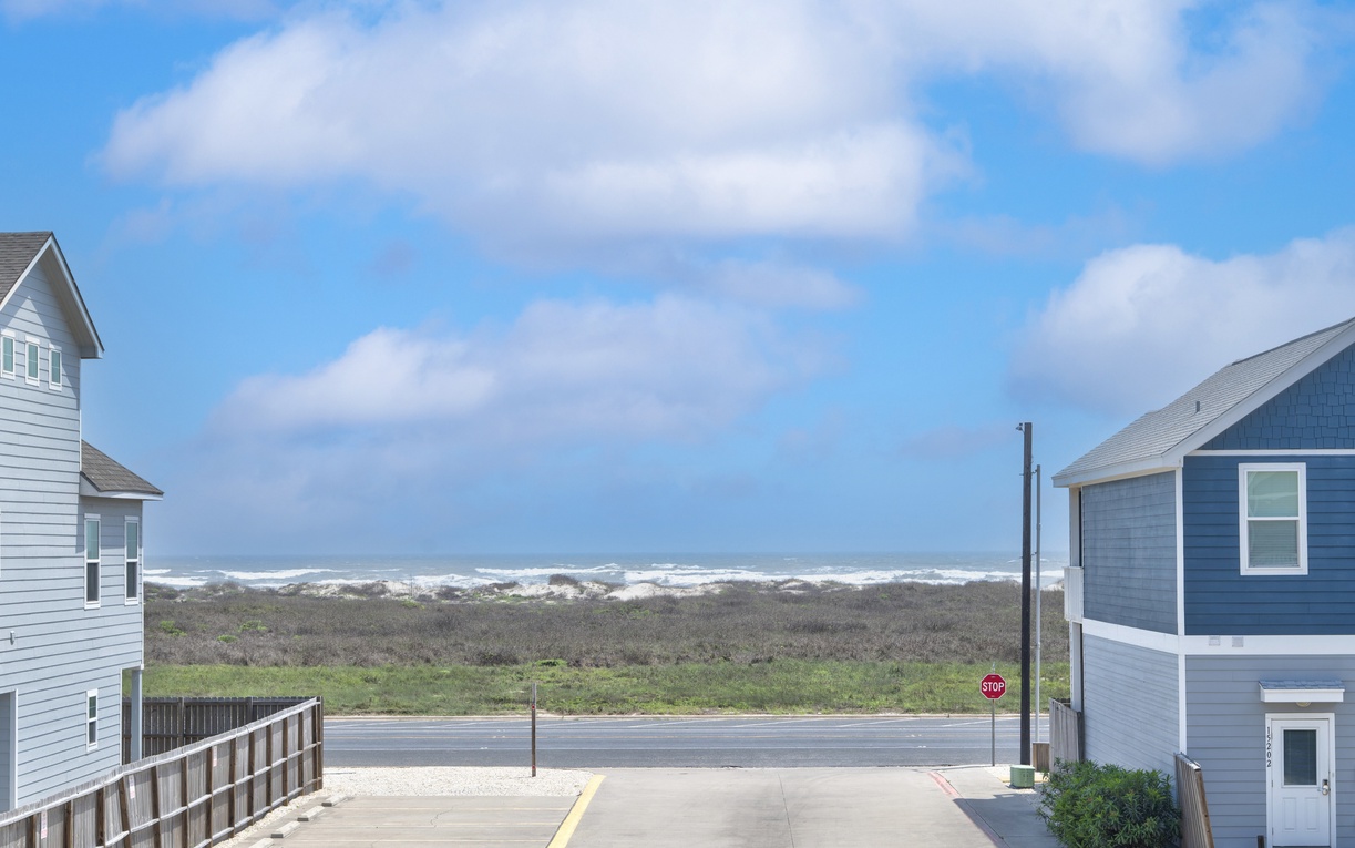 Coastal beach community with ocean views and dune vegetation visible from the property area.