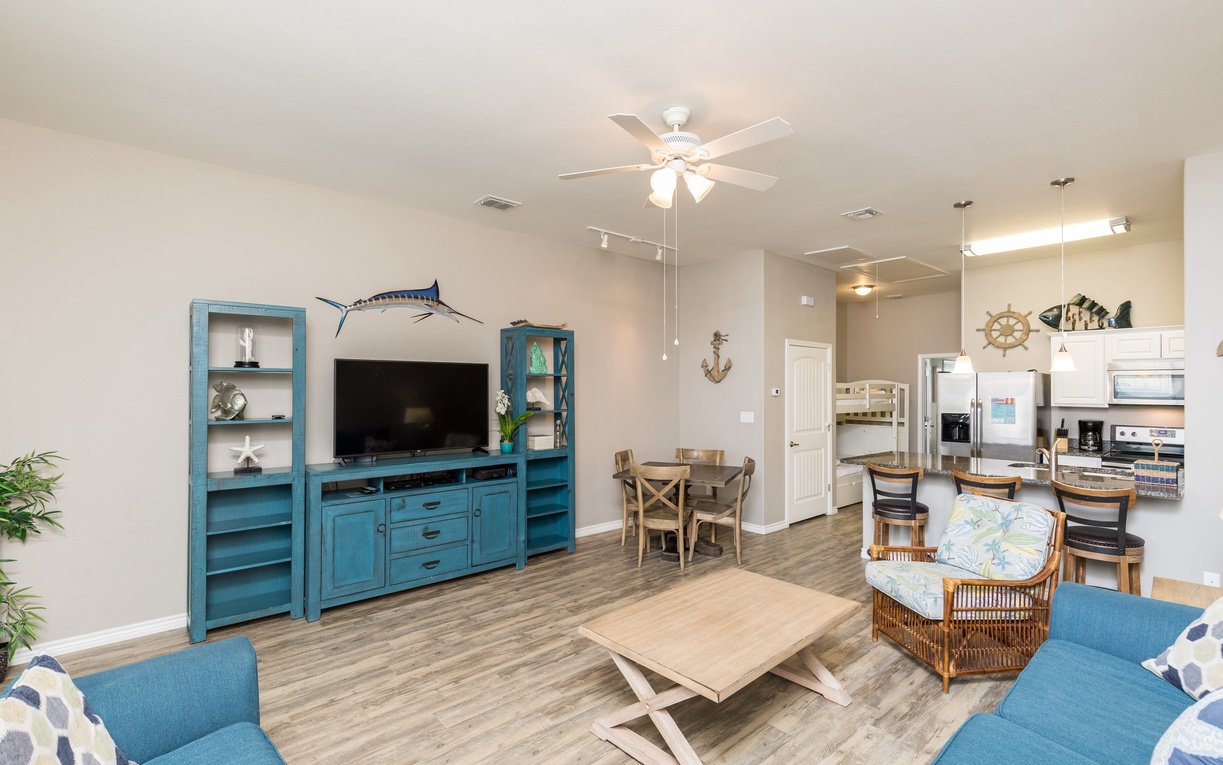 Unwind in your spacious living area with coastal charm, featuring comfortable seating and a fully equipped kitchen for memorable gatherings.