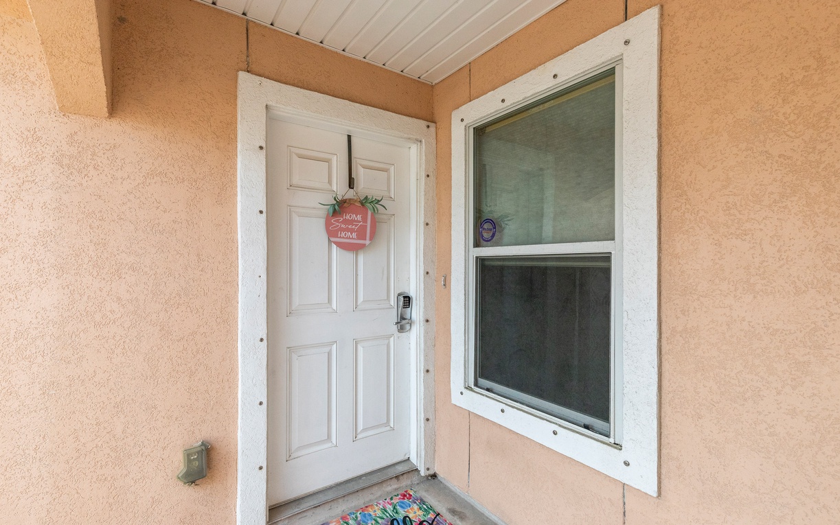 Step through your private entrance adorned with a cheerful welcome sign, where a vibrant doormat sets the tone for your relaxing getaway.