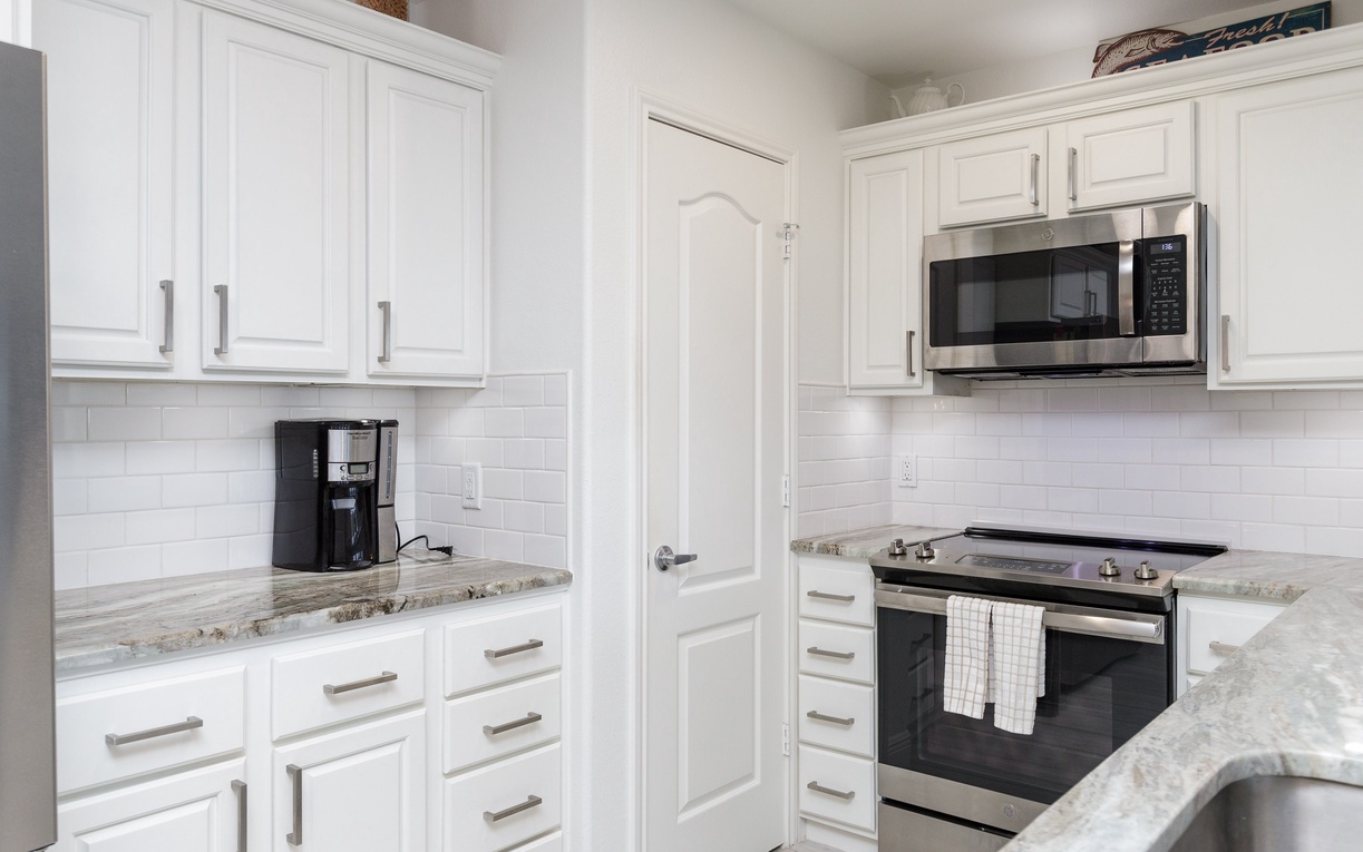 Cook your favorite meals in this bright, fully-equipped kitchen with granite countertops and modern stainless steel appliances.