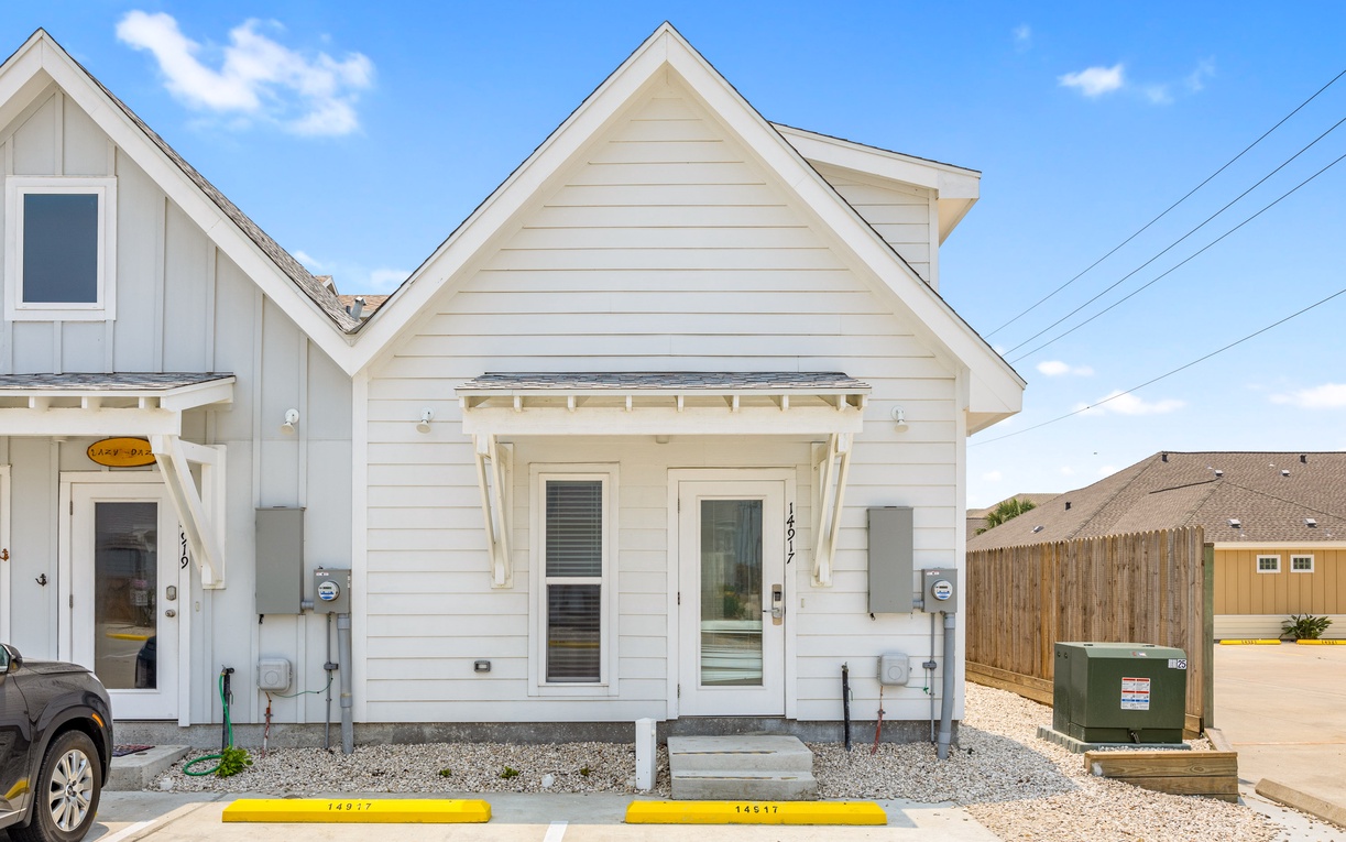 Charming white cottage with modern amenities awaits your arrival in this peaceful neighborhood setting.