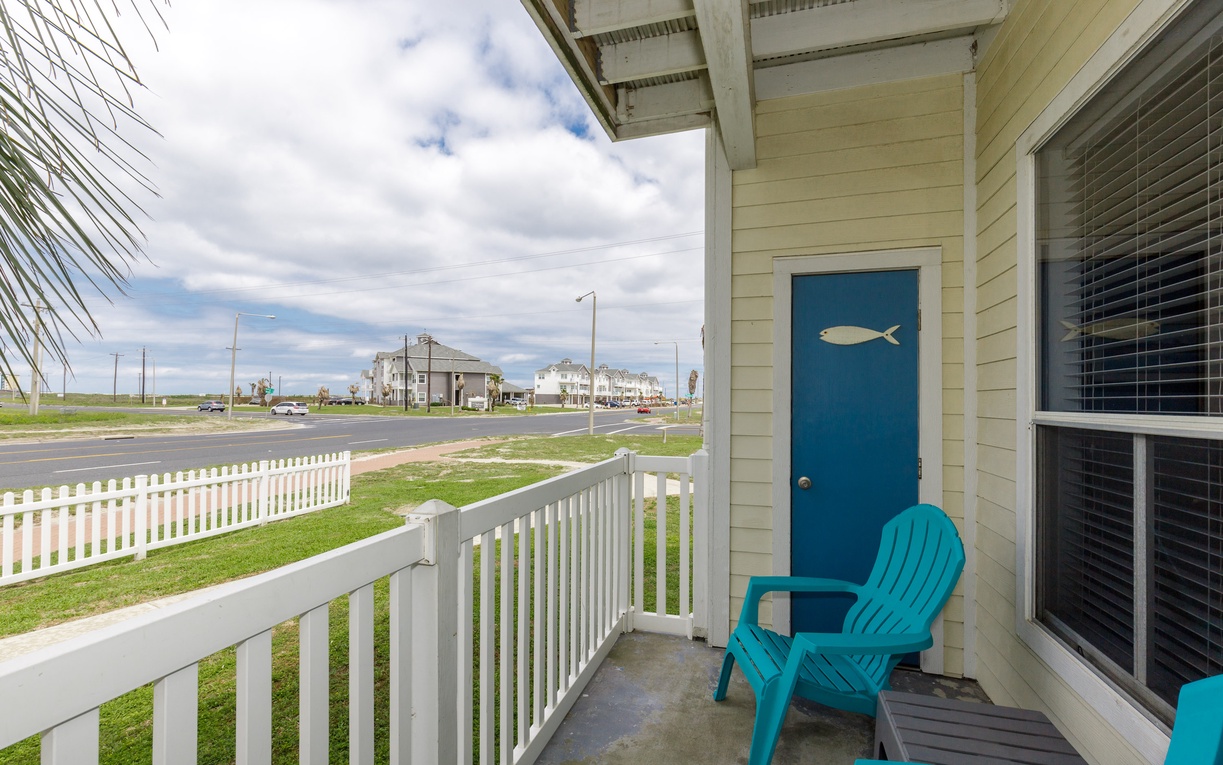 Relax on your private balcony with charming coastal views and cheerful turquoise seating.