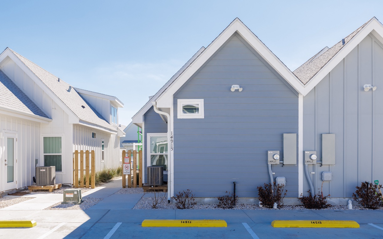 Modern cottage-style buildings in a well-maintained residential complex with dedicated parking spaces and landscaped grounds.