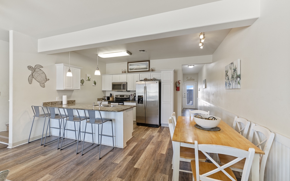 Your bright, open kitchen flows seamlessly into the dining area, perfect for cooking meals together and gathering around the warm wood table.