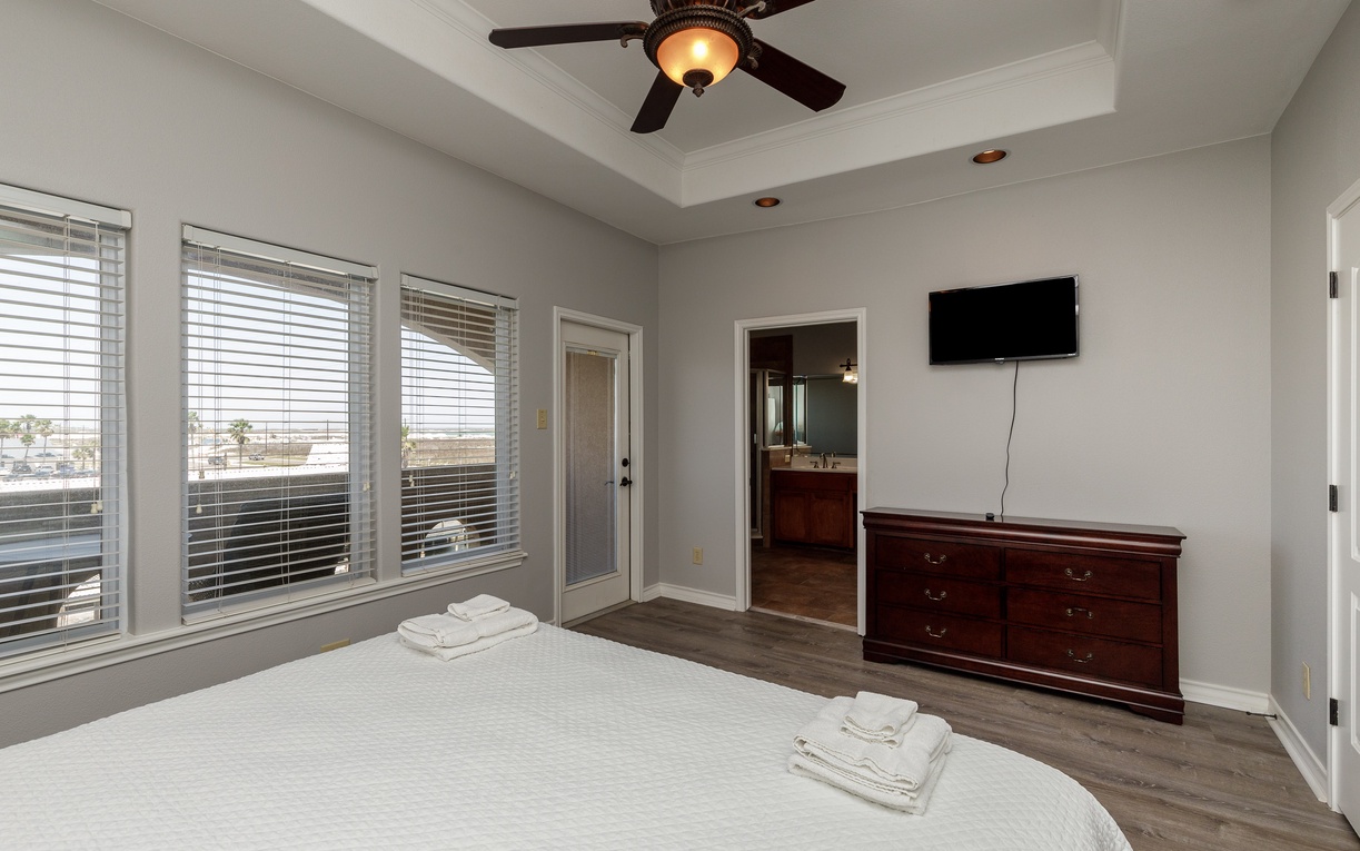 Your bright bedroom offers tray ceilings, elegant furnishings, and private balcony access for morning coffee moments.