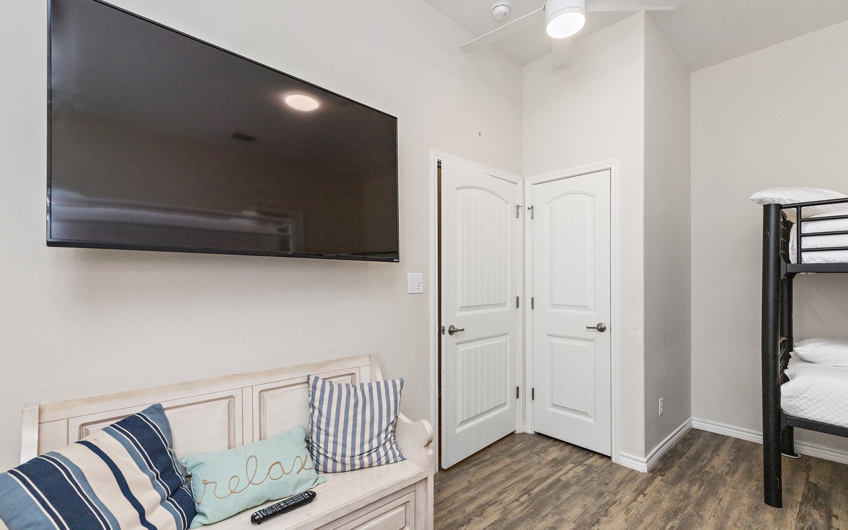 Your cozy retreat features a wall-mounted TV, built-in bench seating, and convenient bunk beds for comfortable group stays.