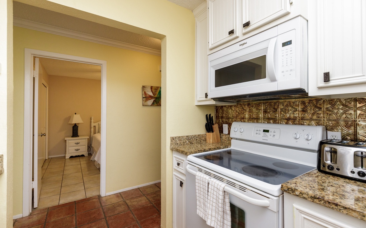 Your fully equipped kitchen features granite counters, ornate backsplash, and all modern appliances for easy home-cooked meals.
