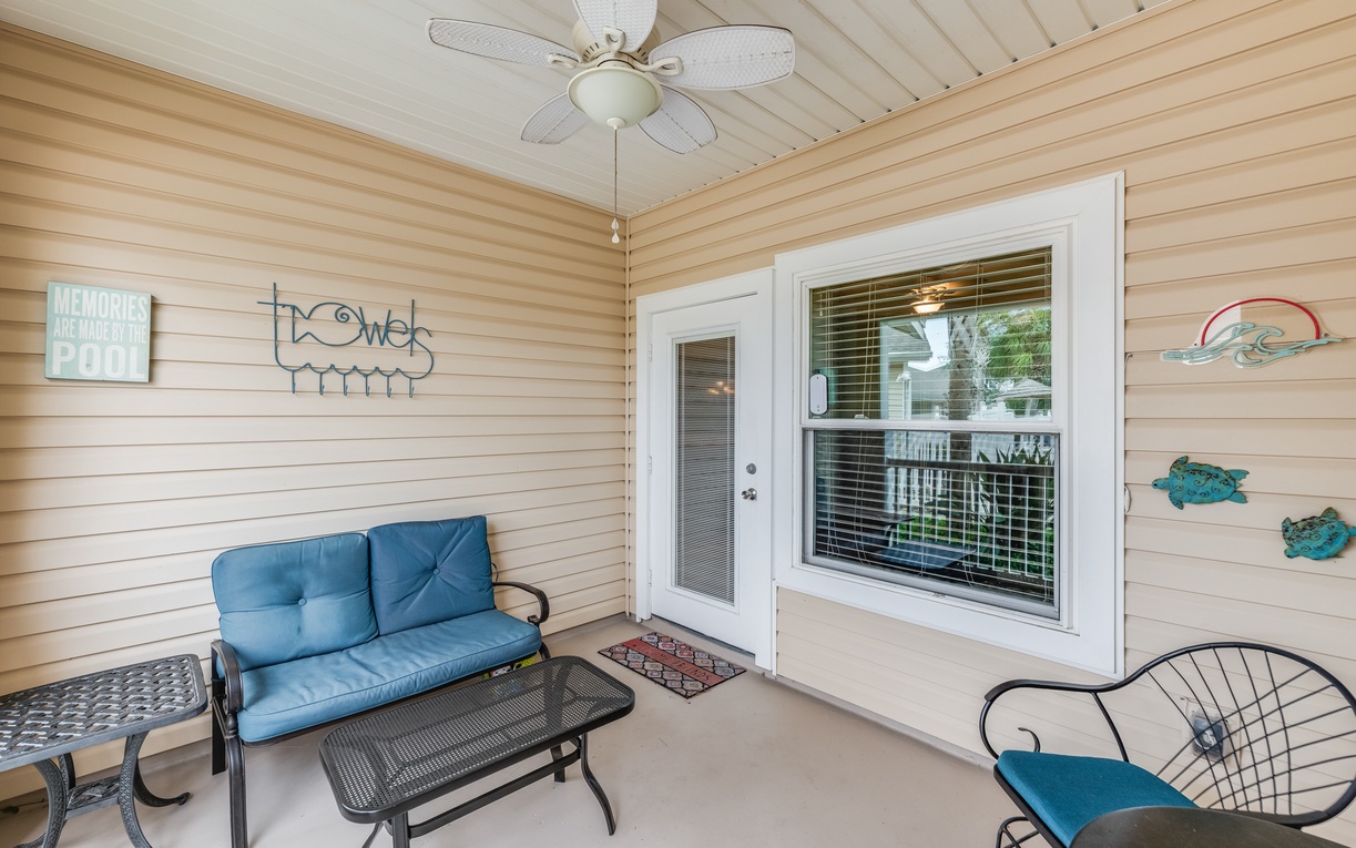 Relax on your private covered porch with coastal charm, featuring comfy seating and a gentle ceiling fan for perfect evening breezes.