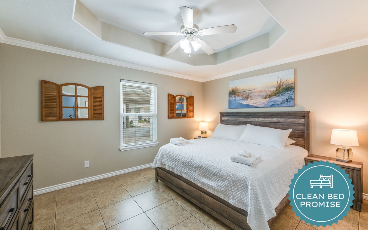 Drift into peaceful sleep beneath a stylish ceiling fan, surrounded by warm coastal touches and crisp white linens.