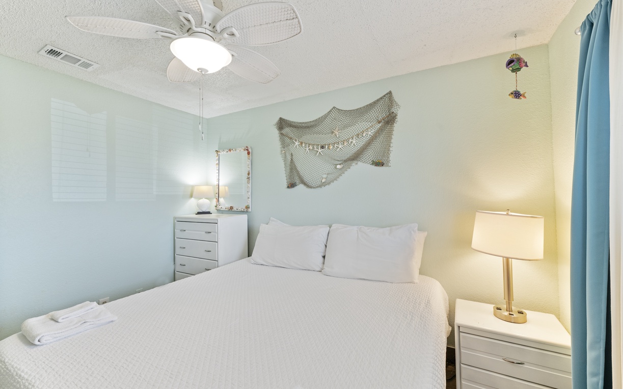 Unwind in your serene coastal-themed bedroom, where soft linens and gentle overhead breezes create the perfect retreat after a day of adventure.
