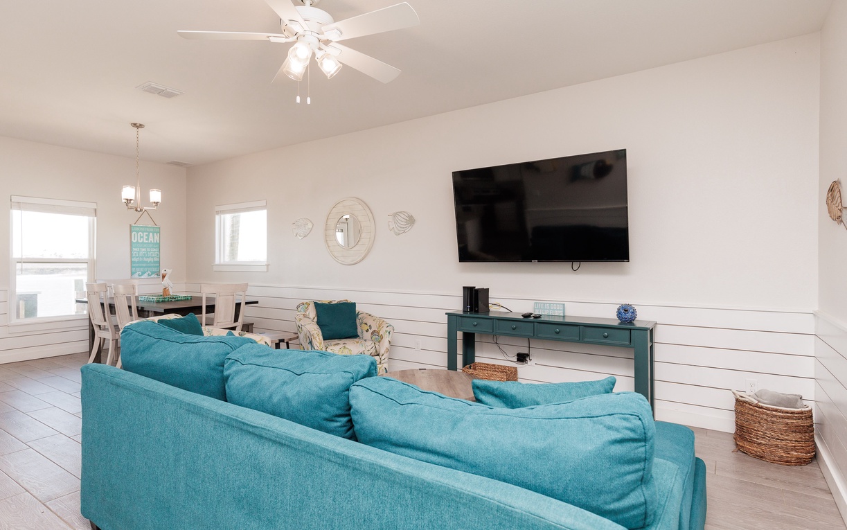 Sink into plush turquoise seating while ocean breezes from your ceiling fan keep you cool as you enjoy movie nights.