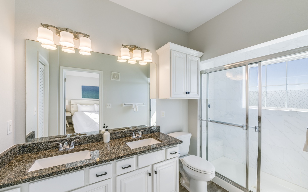 Unwind in your spacious bathroom with dual vanities, granite countertops, and a refreshing glass-enclosed shower.