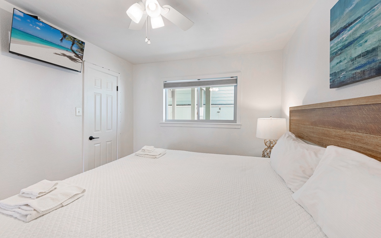 Drift off to peaceful sleep in your cozy bedroom, where ocean artwork and soft lighting create a serene coastal retreat.