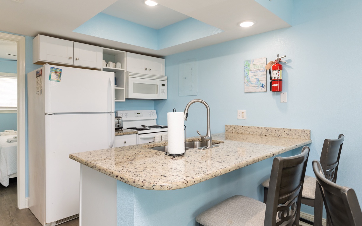 Your fully equipped kitchen awaits with granite countertops, modern appliances, and a breakfast bar where you can enjoy morning coffee together.