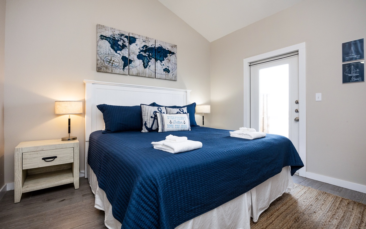 Drift off to dreamland in your cozy bedroom with crisp white linens, nautical blue accents, and soft bedside lighting.