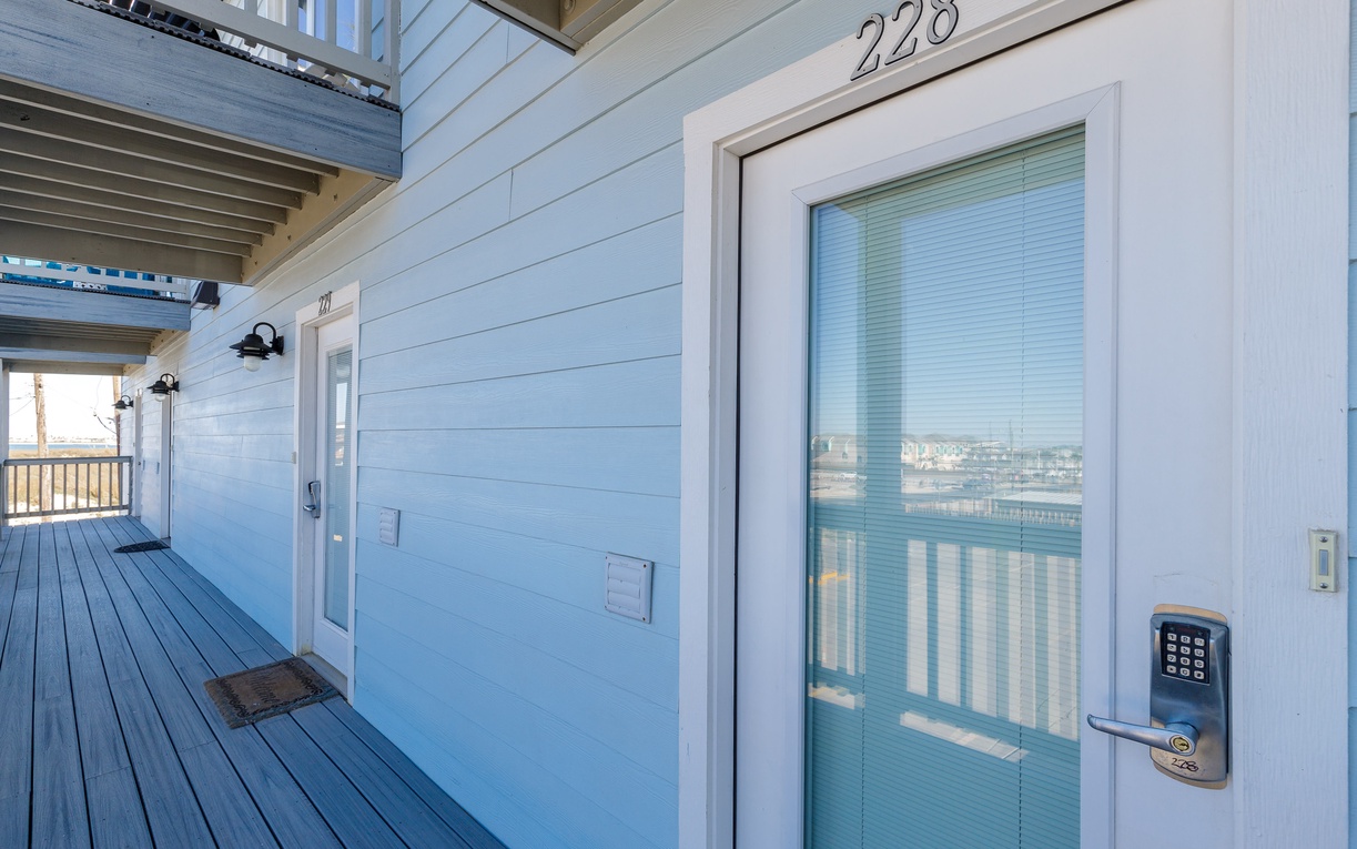 A clean, modern entrance to unit 228 with electronic keypad access for added security.