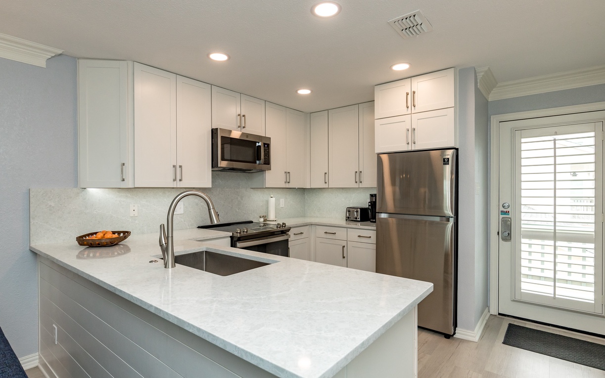 Your fully equipped kitchen features sleek white cabinets, granite countertops, and stainless steel appliances for all your culinary needs.