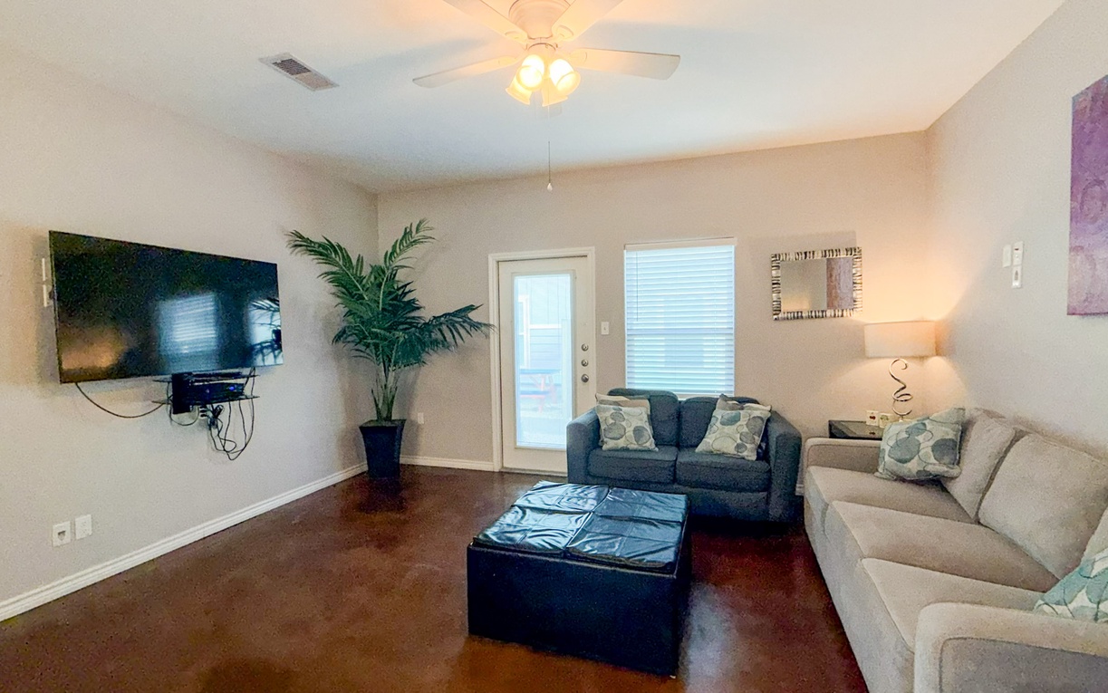 Unwind in your spacious living room with plush seating, modern entertainment, and warm lighting creating the perfect atmosphere for relaxation.
