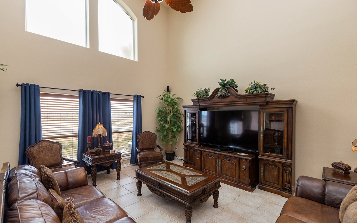 Sink into plush leather seating in your spacious living room, where soaring ceilings and tropical touches create the perfect retreat for relaxation.