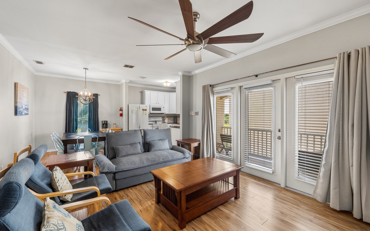 Relax in your bright, open-concept living space on the second floor with cozy furnishings, modern kitchen, and private balcony access for the perfect home-away-from-home experience.