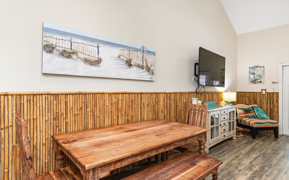Gather around your rustic dining table for memorable meals, while beach-themed artwork and warm bamboo accents create a cozy coastal retreat atmosphere.