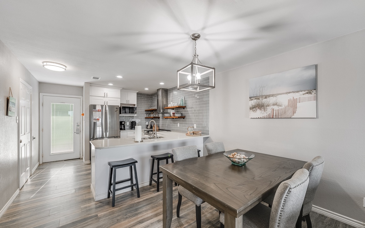 Your modern kitchen flows seamlessly into the dining space, where you'll gather around the stylish table under elegant pendant lighting.