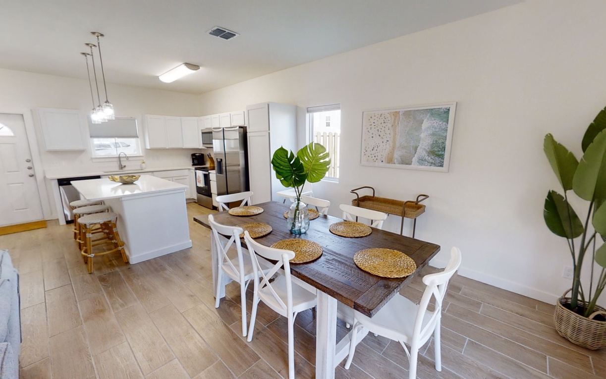 Your open-plan kitchen flows seamlessly into a bright dining space with tropical touches and coastal-inspired décor.
