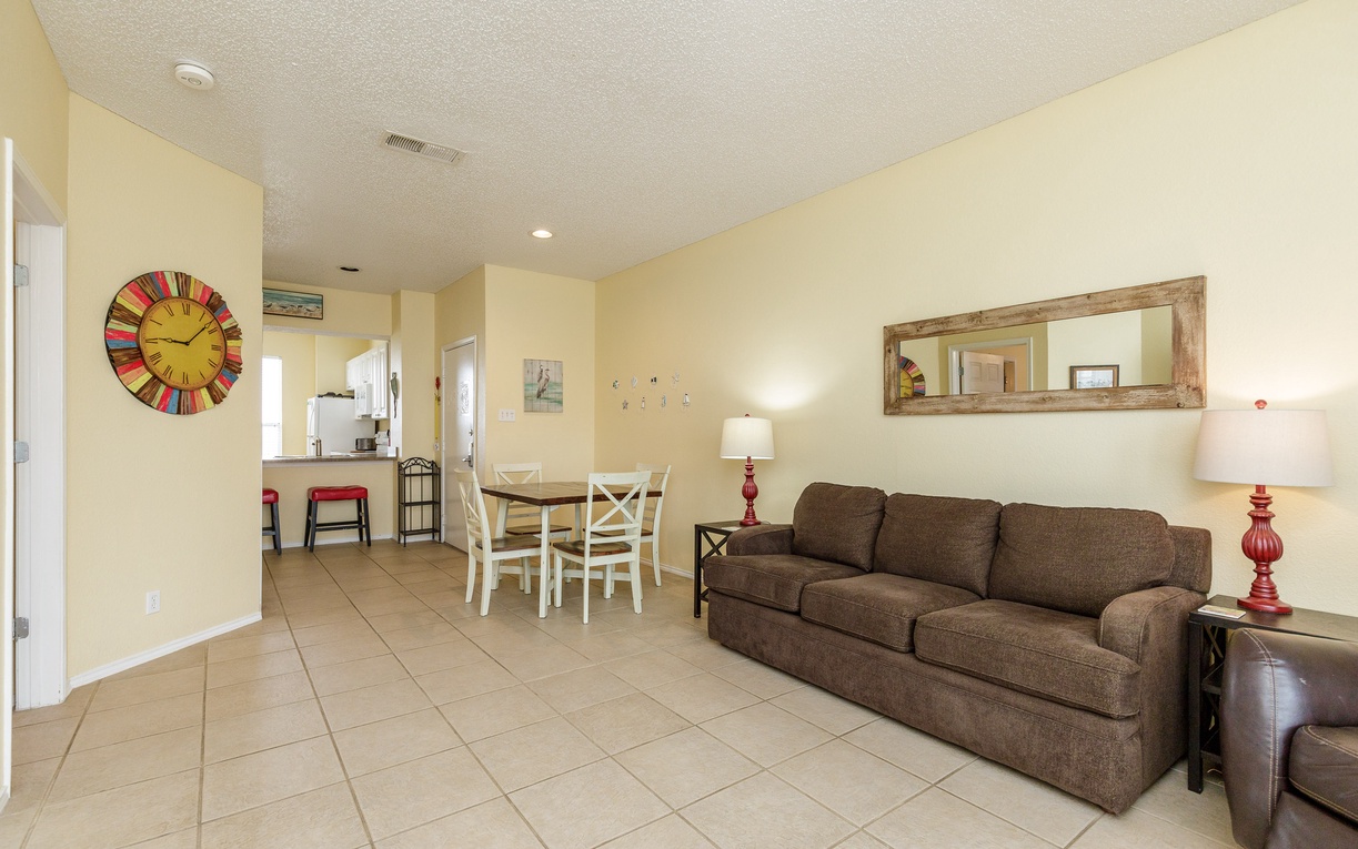 Unwind in your open living space with comfortable seating, dining table, and charming décor that creates the perfect home-away-from-home atmosphere.