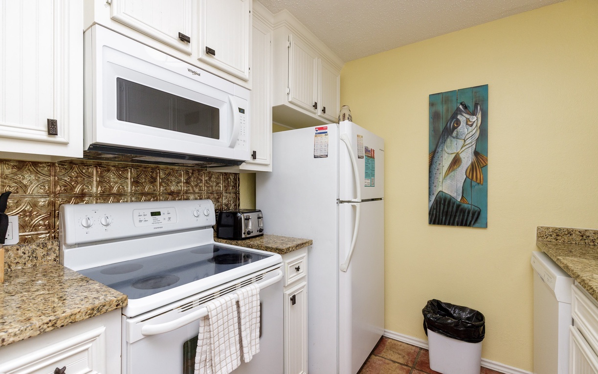 Cook your favorite meals in this bright kitchen with granite counters, white appliances, and decorative tile backsplash.