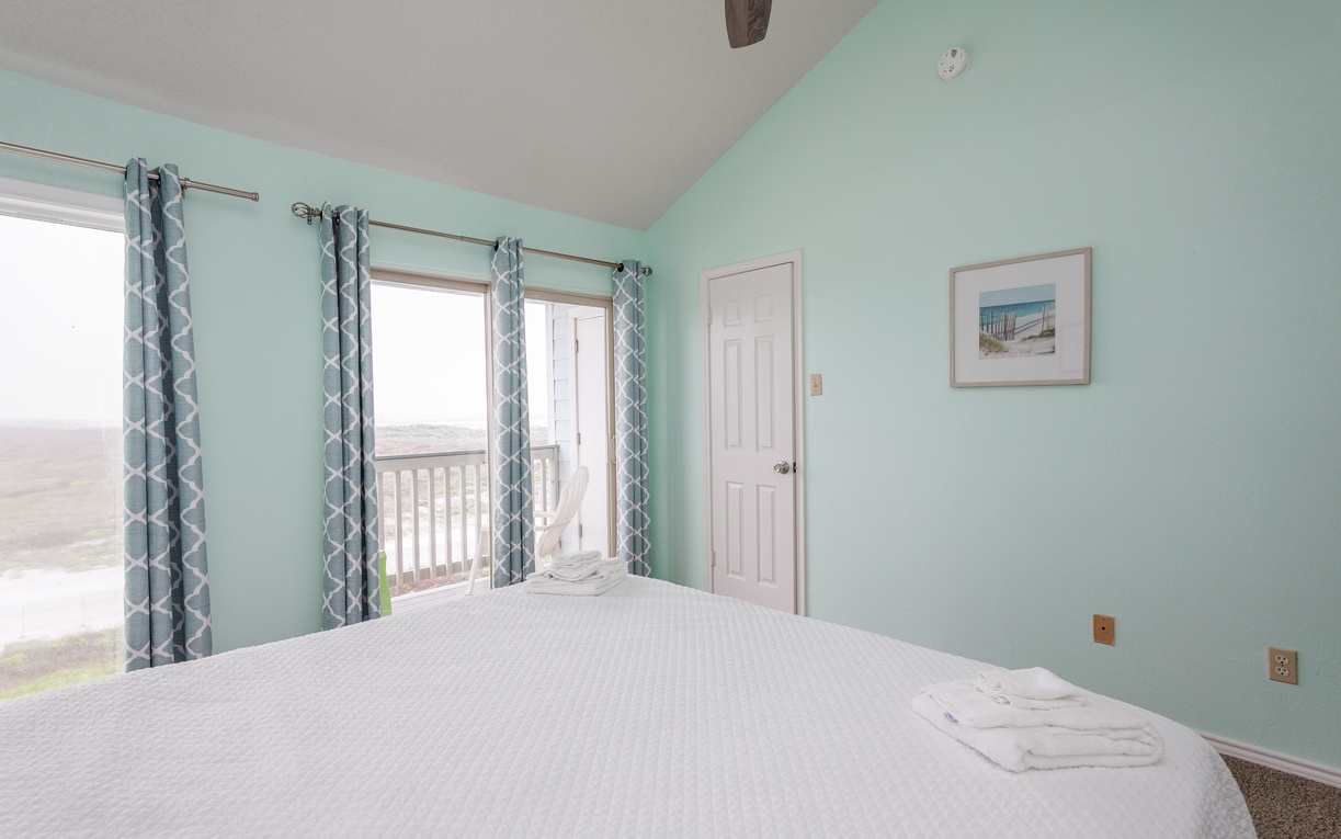 Drift off in your peaceful bedroom with calming mint walls and crisp linens, as natural light filters through patterned curtains.
