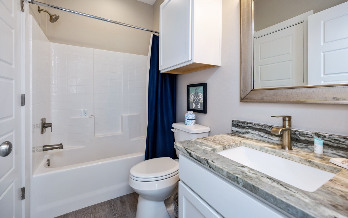 Freshen up in your stylish bathroom featuring elegant granite countertops, modern fixtures, and a relaxing tub-shower combo.