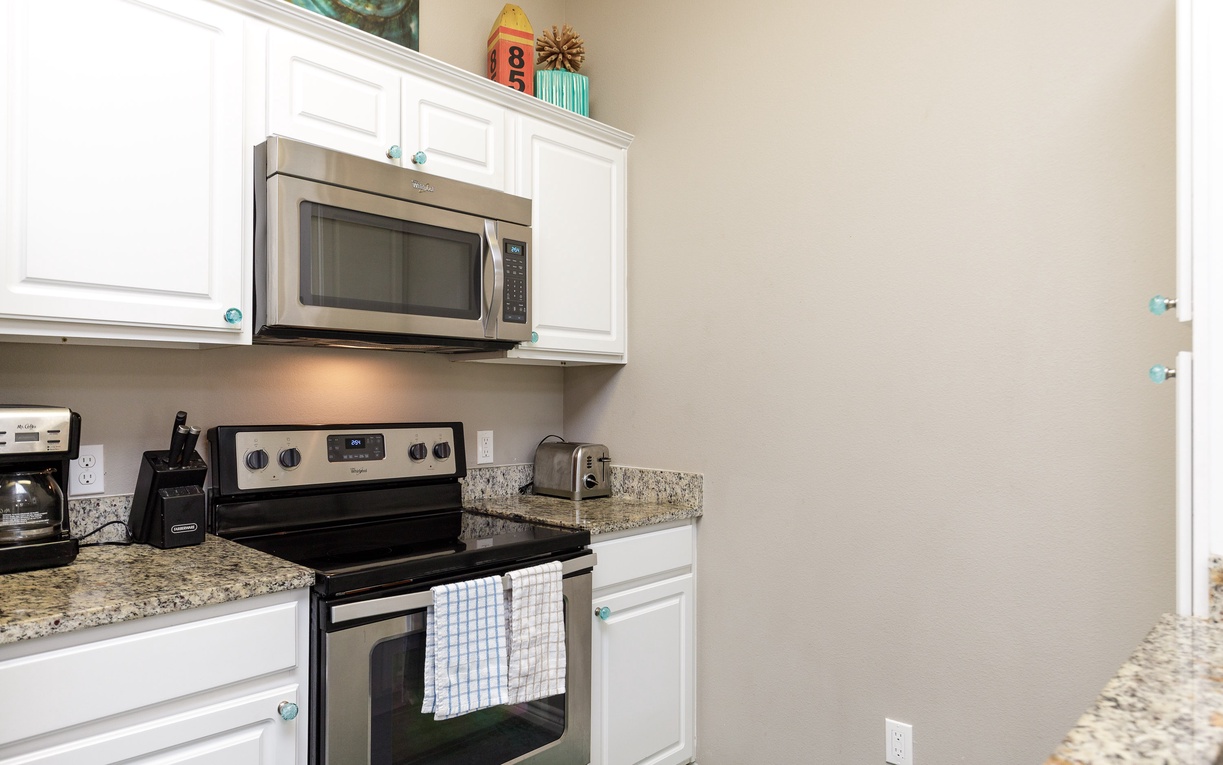 Your modern kitchen features granite countertops, stainless steel appliances, and crisp white cabinetry - perfect for preparing meals during your stay.