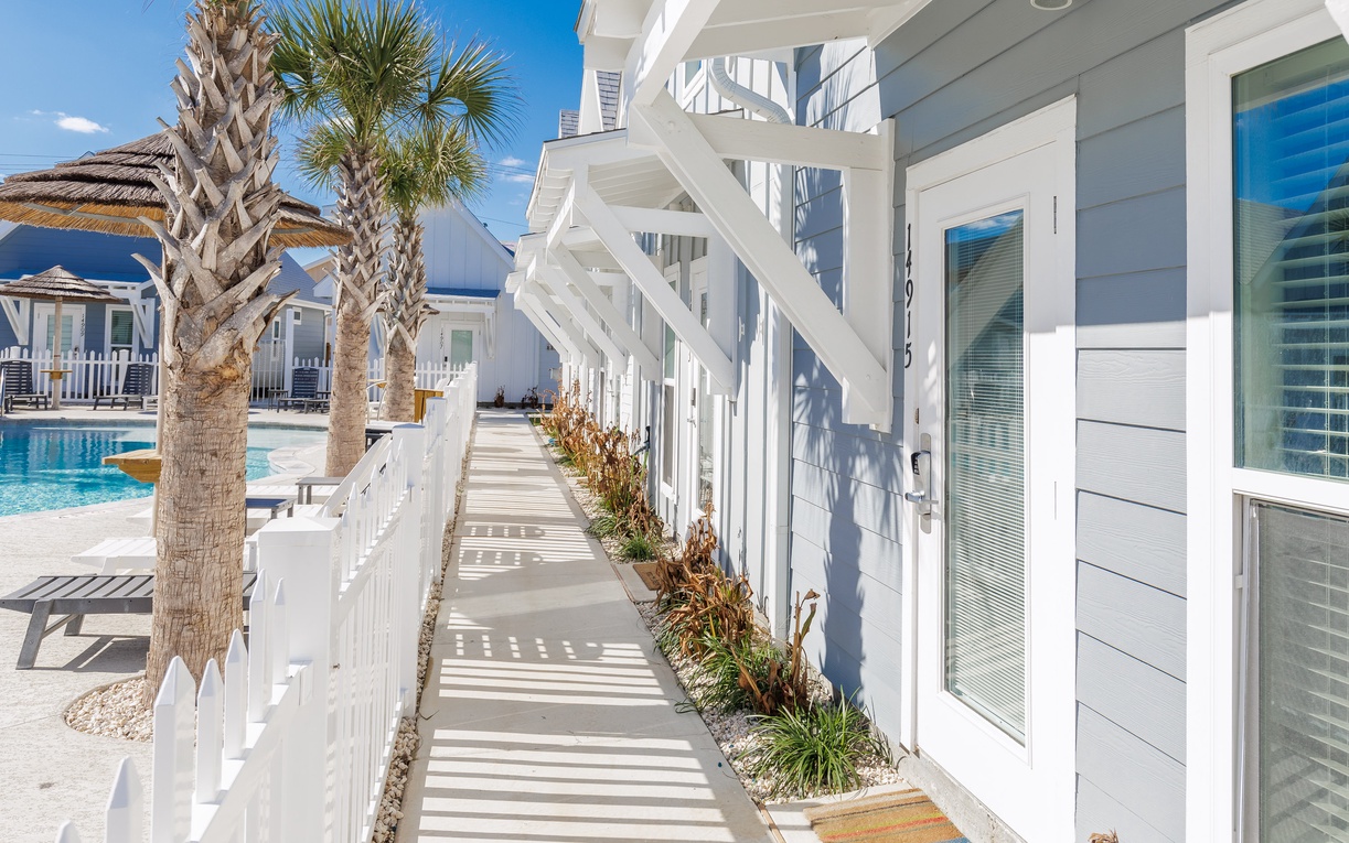 Bright coastal architecture features clean lines and tropical landscaping around the pool area.
