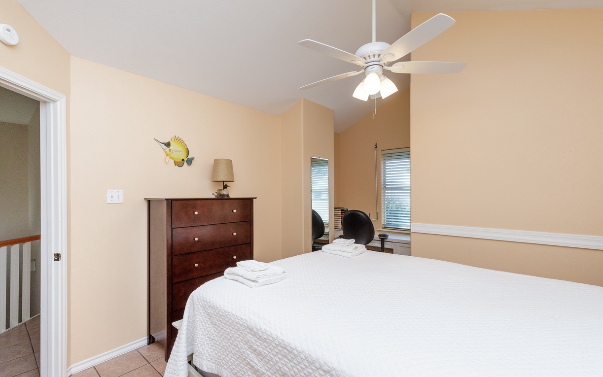 Rest peacefully in your comfortable bedroom with crisp linens and coastal charm, where gentle breezes from the ceiling fan ensure sweet dreams.